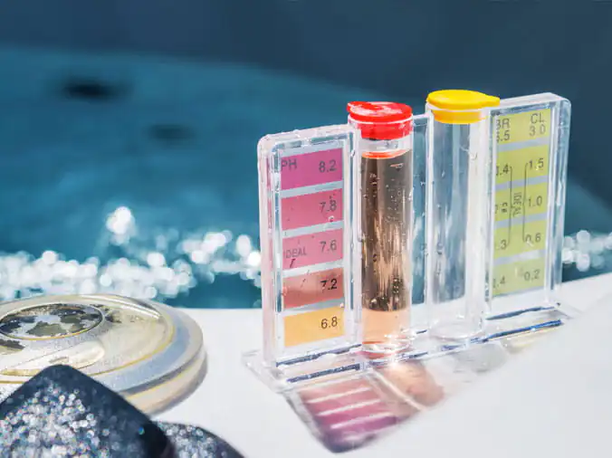 Pool water testing kit on the side of a swimming pool